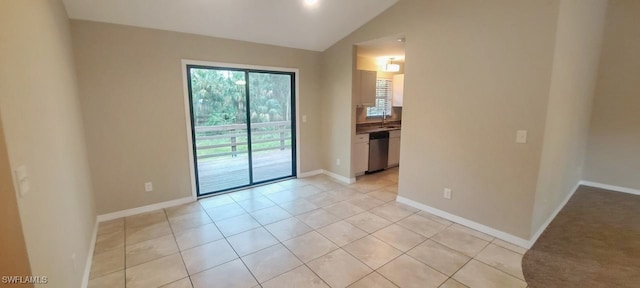 tiled empty room featuring lofted ceiling