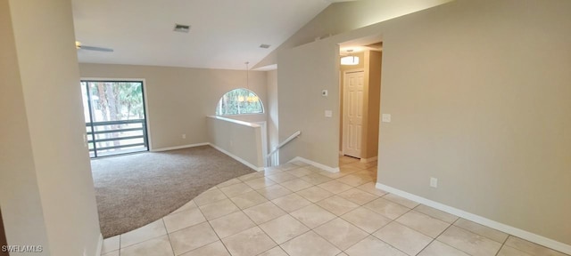 carpeted empty room with vaulted ceiling