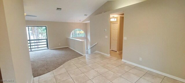 880 Wilson Blvd N, Naples, FL 34120 - unfurnished room with light carpet, light tile patterned floors, and vaulted ceiling