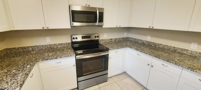 kitchen with dark stone countertops, white cabinets, and appliances with stainless steel finishes