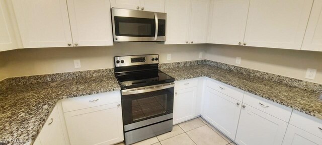 880 Wilson Blvd N, Naples, FL 34120 - kitchen featuring stainless steel appliances, white cabinets, and dark stone counters