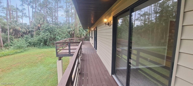 wooden deck featuring a lawn