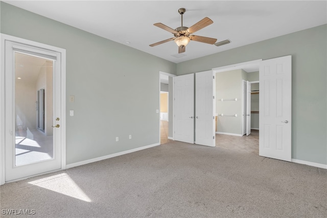 unfurnished bedroom featuring a spacious closet, ceiling fan, and carpet floors