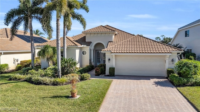 mediterranean / spanish-style house featuring a garage and a front lawn