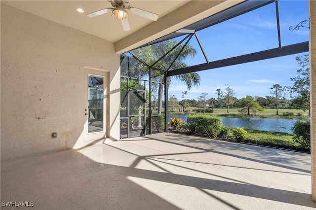 view of patio / terrace featuring a water view, ceiling fan, and a lanai