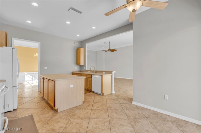 kitchen with sink, a center island, light brown cabinets, kitchen peninsula, and white appliances