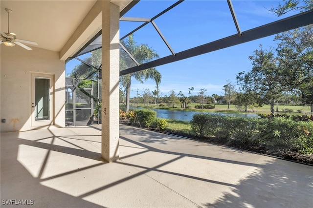 view of patio featuring a lanai, ceiling fan, and a water view