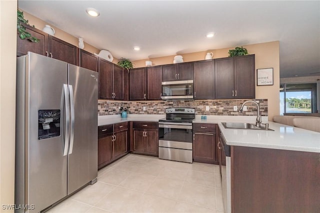 kitchen featuring dark brown cabinetry, appliances with stainless steel finishes, backsplash, and a sink