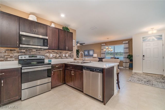 kitchen featuring decorative backsplash, stainless steel appliances, a sink, and light countertops