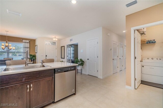 kitchen with washer / dryer, visible vents, dark brown cabinets, stainless steel dishwasher, and a sink