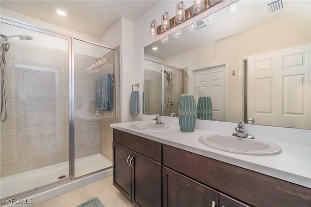 bathroom featuring a stall shower, visible vents, a sink, and tile patterned floors