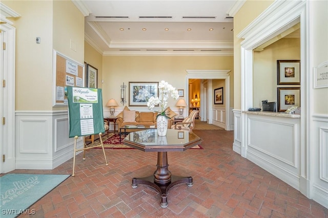 interior space featuring brick floor, recessed lighting, a wainscoted wall, a decorative wall, and ornamental molding