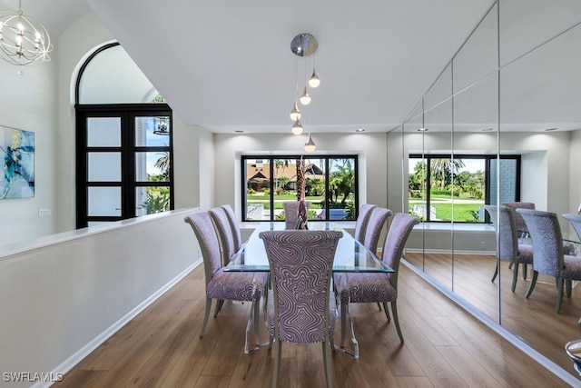 dining area featuring hardwood / wood-style floors and a notable chandelier