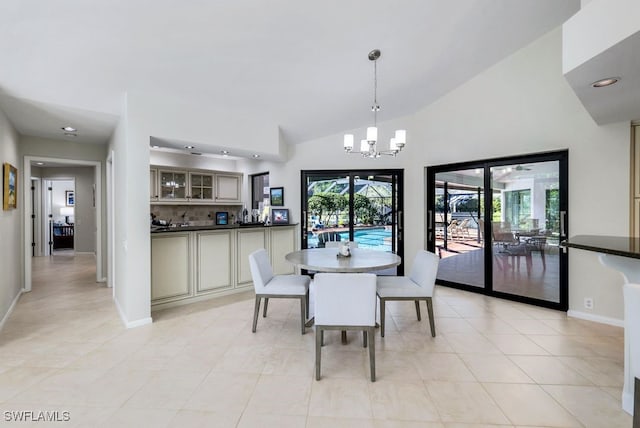 tiled dining room featuring lofted ceiling and an inviting chandelier