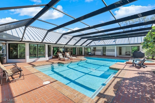 view of swimming pool with glass enclosure and a patio area