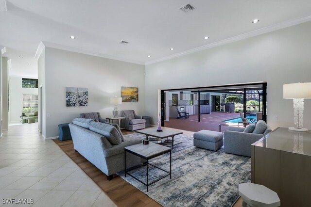 living room with light tile patterned floors and crown molding