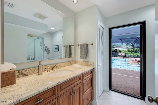 bathroom featuring tile patterned flooring, vanity, and a shower with shower door