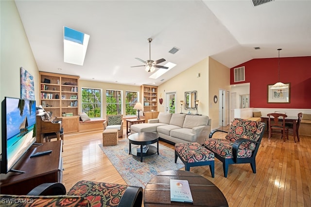 living room with ceiling fan, light hardwood / wood-style floors, and vaulted ceiling