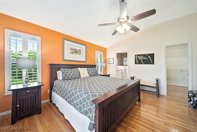 bedroom featuring lofted ceiling, a walk in closet, ceiling fan, light hardwood / wood-style floors, and a closet