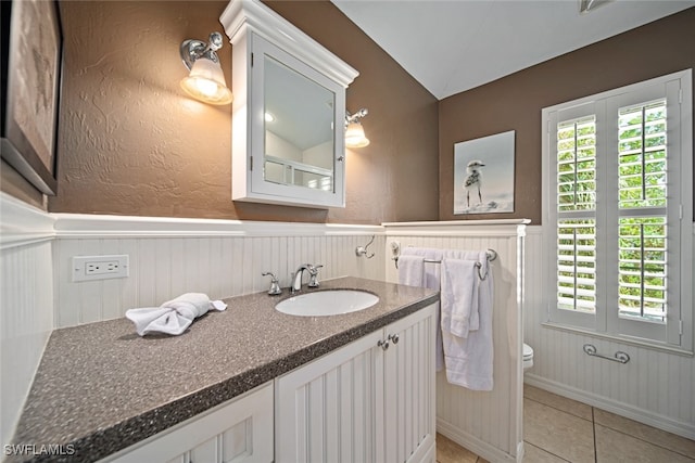 bathroom featuring toilet, vanity, tile patterned floors, and lofted ceiling