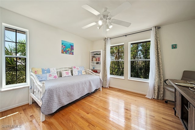 bedroom with multiple windows, ceiling fan, and light hardwood / wood-style flooring