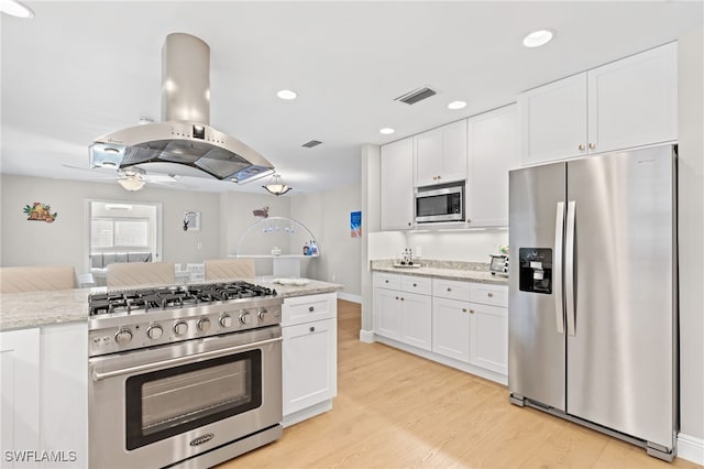 kitchen featuring stainless steel appliances, white cabinetry, and island range hood