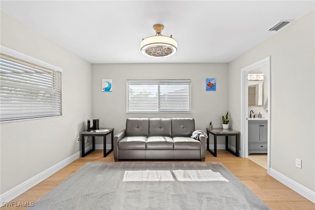 living room with sink and light hardwood / wood-style floors