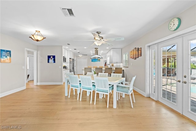 dining space with ceiling fan, french doors, and light hardwood / wood-style floors