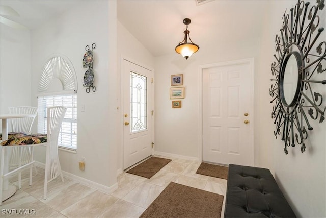 foyer featuring plenty of natural light and vaulted ceiling