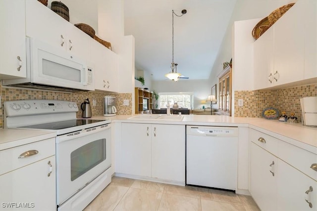 kitchen featuring white appliances, a sink, decorative backsplash, light countertops, and pendant lighting