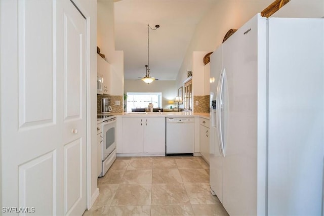 kitchen with tasteful backsplash, white appliances, white cabinets, light countertops, and lofted ceiling