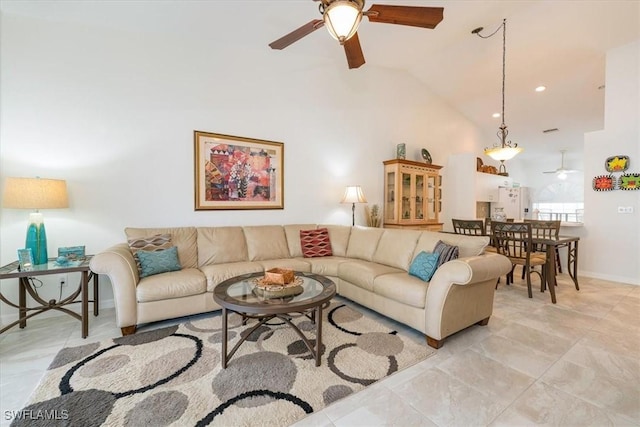 living area with baseboards, a ceiling fan, and vaulted ceiling