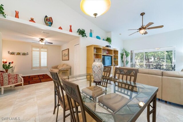 tiled dining area featuring ceiling fan, plenty of natural light, and high vaulted ceiling