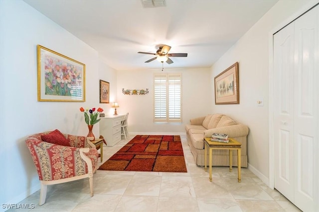 sitting room with visible vents, baseboards, and ceiling fan