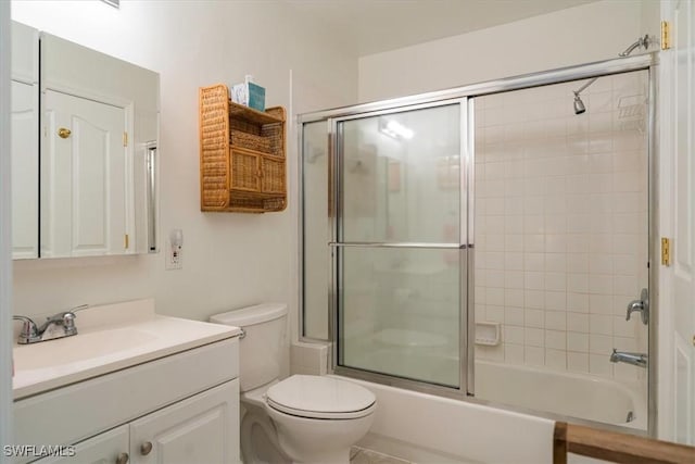 bathroom featuring vanity, toilet, and shower / bath combination with glass door