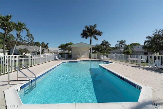 pool with a patio and fence