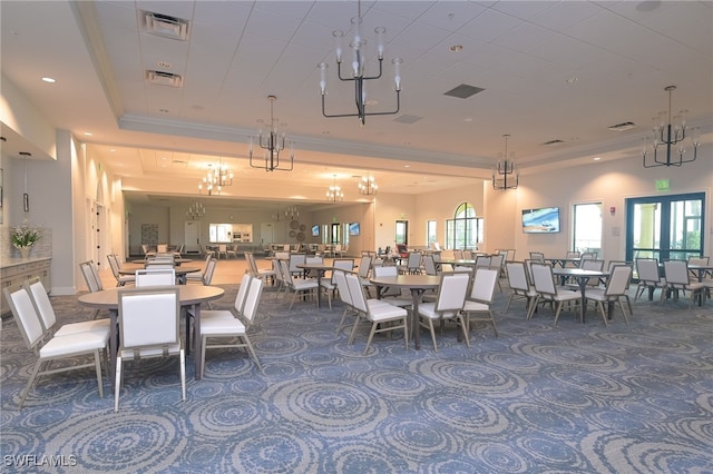 dining area with a tray ceiling, visible vents, and crown molding