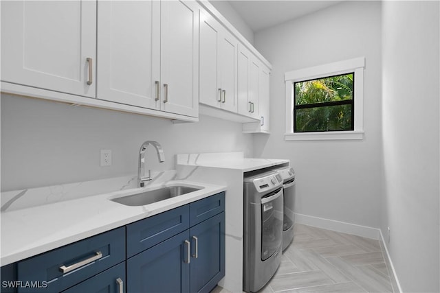 laundry area featuring cabinets, light parquet floors, washing machine and clothes dryer, and sink