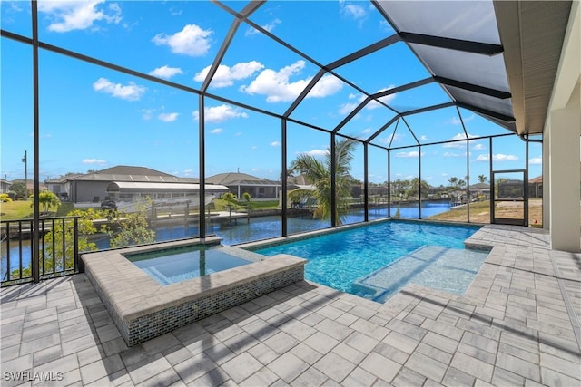 view of swimming pool with a patio area, a lanai, an in ground hot tub, and a water view