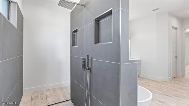 bathroom featuring walk in shower, vanity, and hardwood / wood-style floors