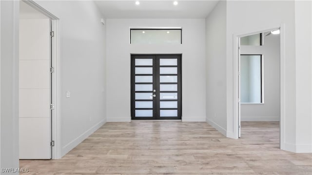 entryway with light hardwood / wood-style floors and french doors