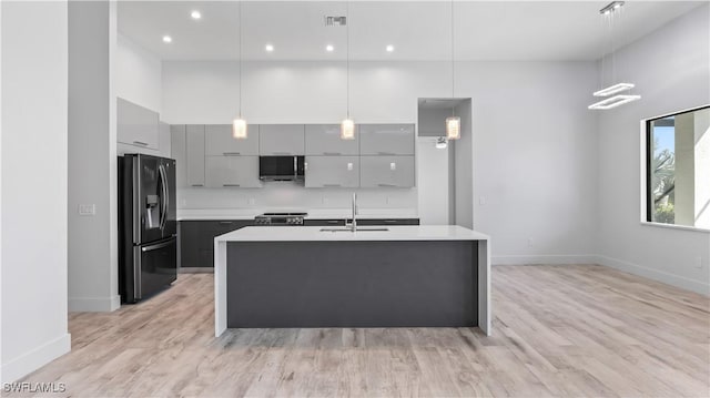 kitchen with stainless steel appliances, hanging light fixtures, sink, and gray cabinetry