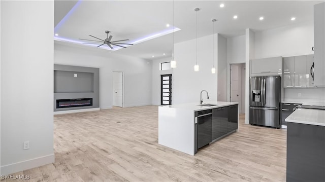 kitchen featuring stainless steel refrigerator with ice dispenser, sink, hanging light fixtures, black dishwasher, and ceiling fan