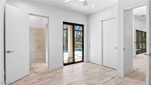 unfurnished bedroom featuring connected bathroom, access to exterior, ceiling fan, light hardwood / wood-style floors, and a closet