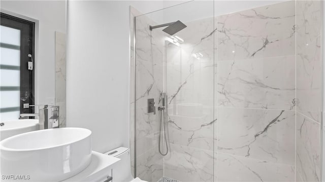 bathroom with sink, toilet, and tiled shower