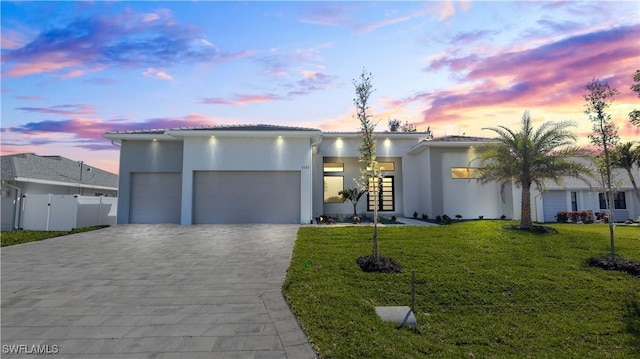 view of front facade featuring a garage and a lawn