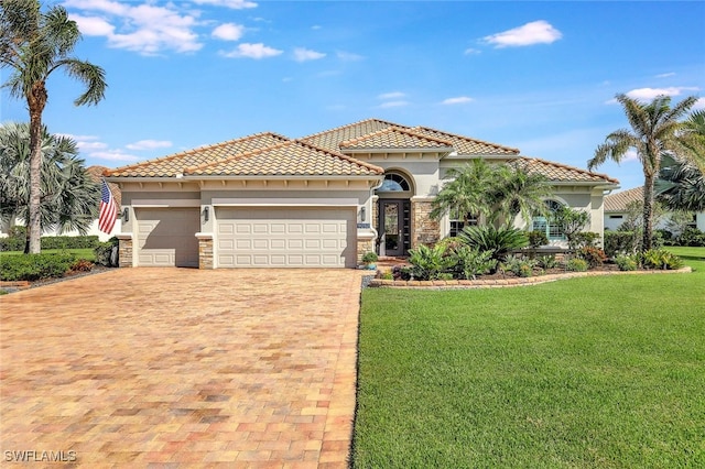 mediterranean / spanish house featuring a garage and a front lawn