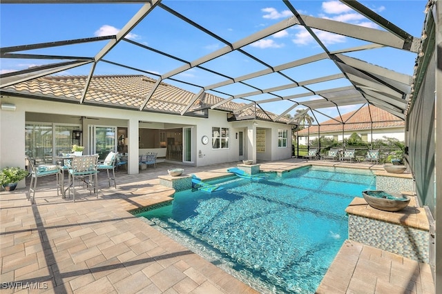 view of pool with glass enclosure and a patio