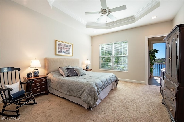 carpeted bedroom with a tray ceiling, ceiling fan, ornamental molding, and access to outside