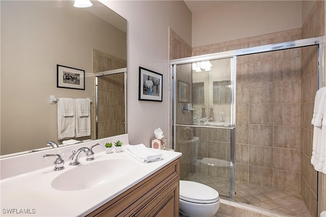 bathroom featuring vanity, toilet, and an enclosed shower